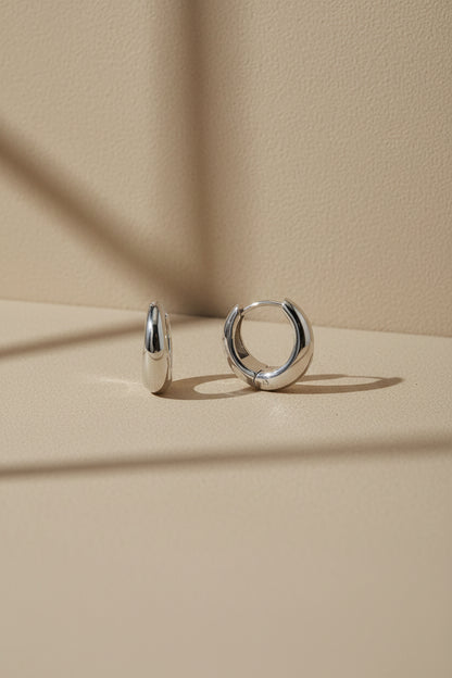 Pendientes aro huggi de plata, argollas pequeñas con acabado liso y cierre tipo aro.