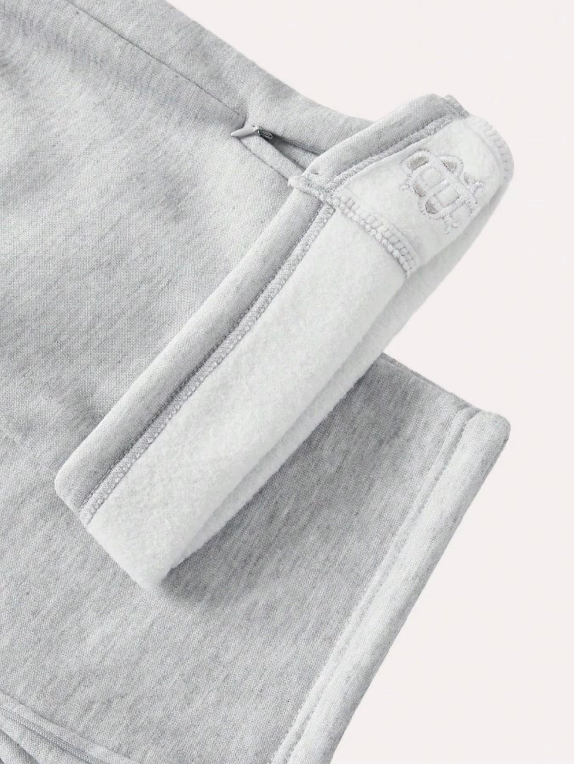Pantalón chándal gris oversize con dobladillo y ribete elástico, logo bordado blanco