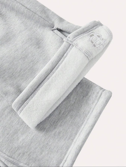 Pantalón chándal gris oversize con dobladillo y ribete elástico, logo bordado blanco