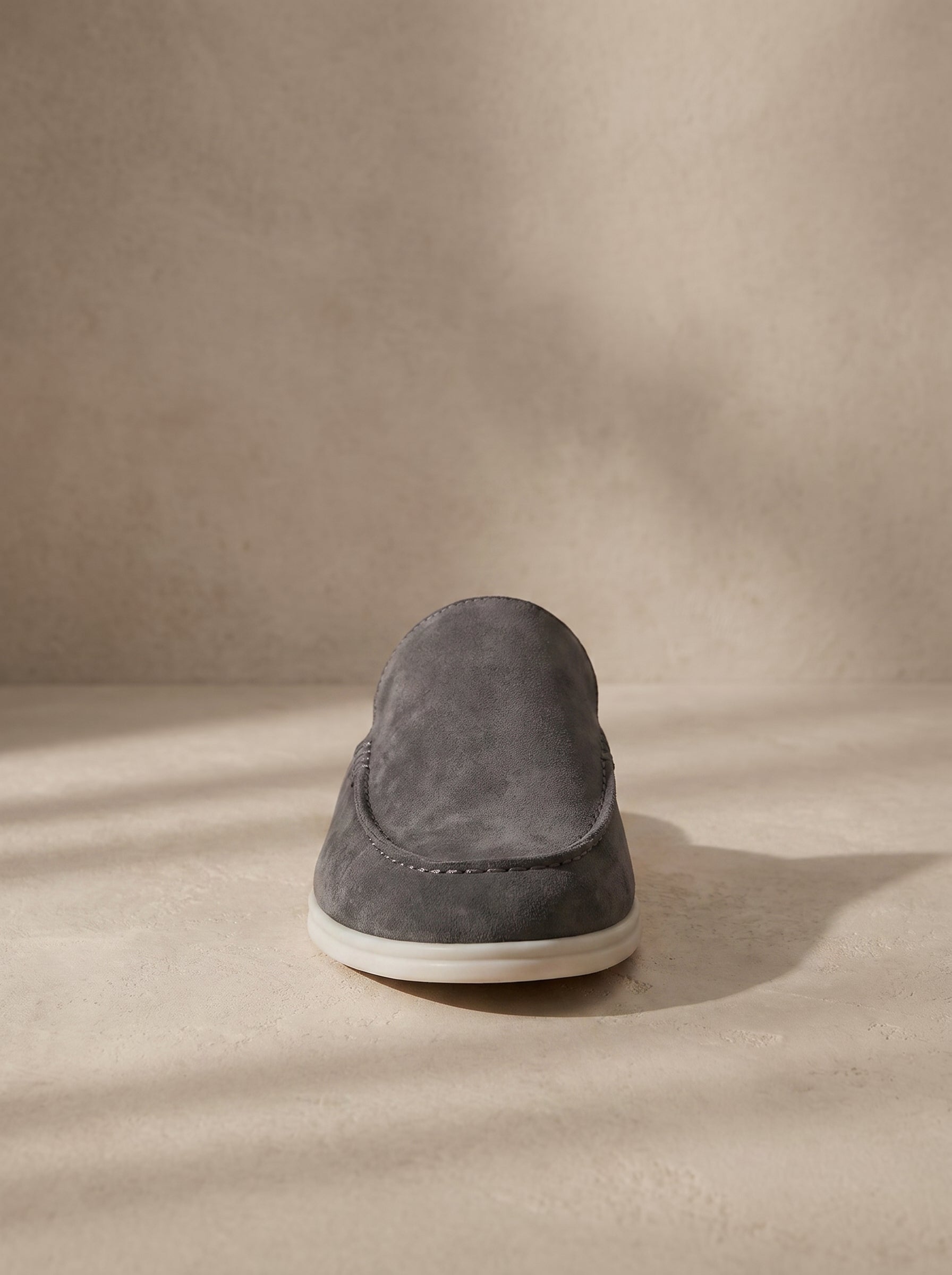 Mocasín mule de ante gris oscuro con suela blanca y diseño tipo slip-on