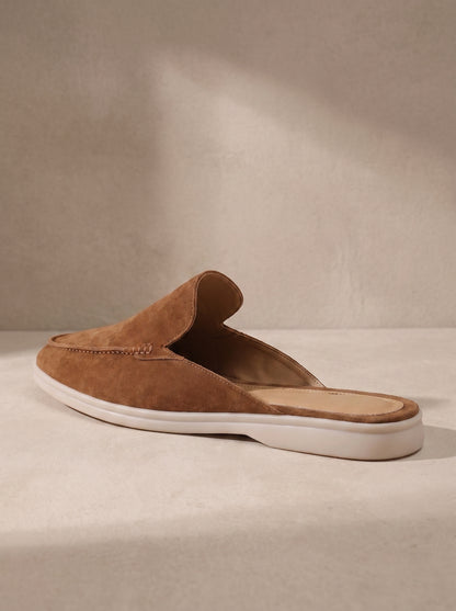 Mocasín mule de ante camel con costuras y suela blanca.