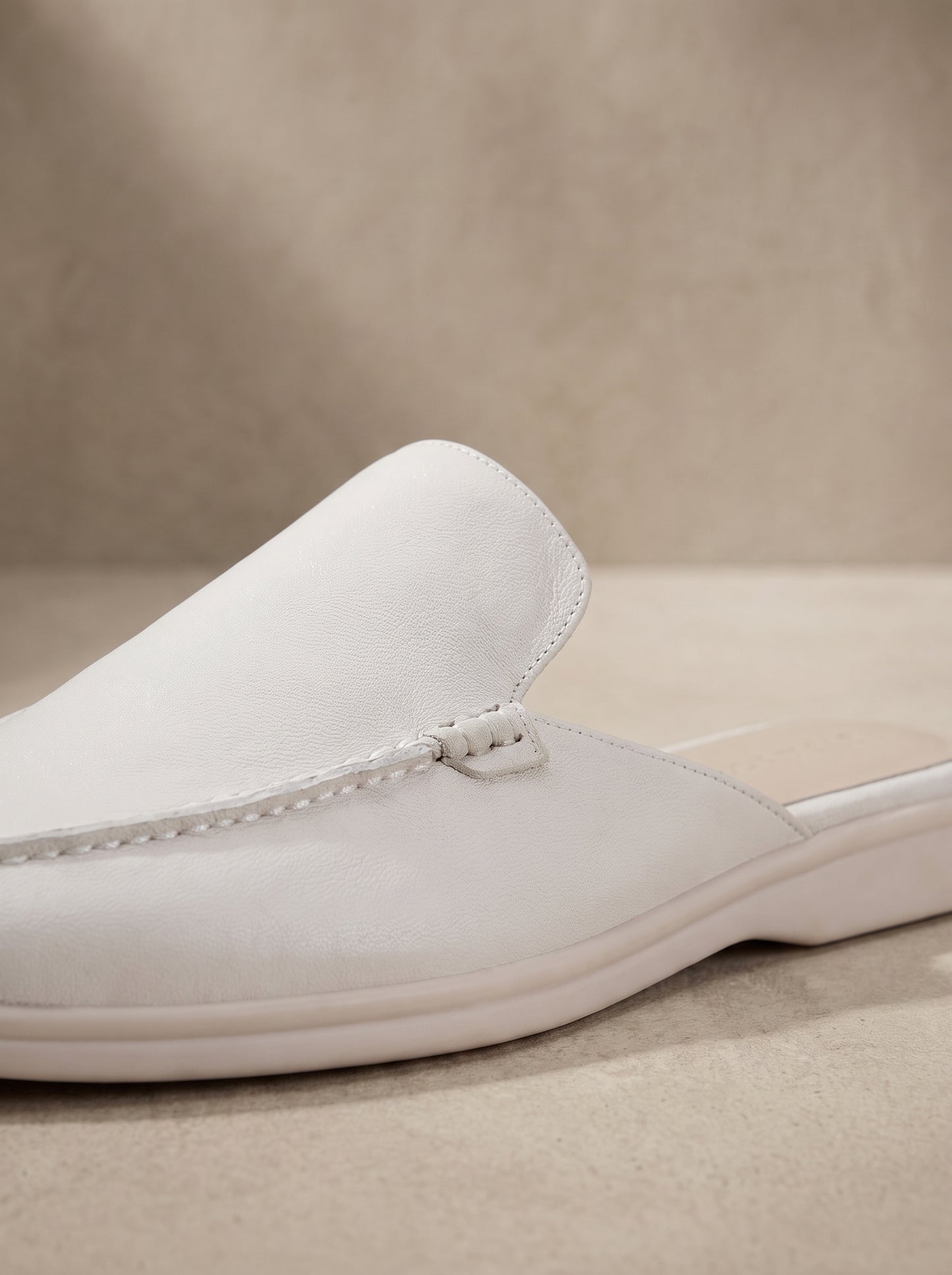 Mocasín mule de ante blanco con detalle de bies y lazo en la pala.