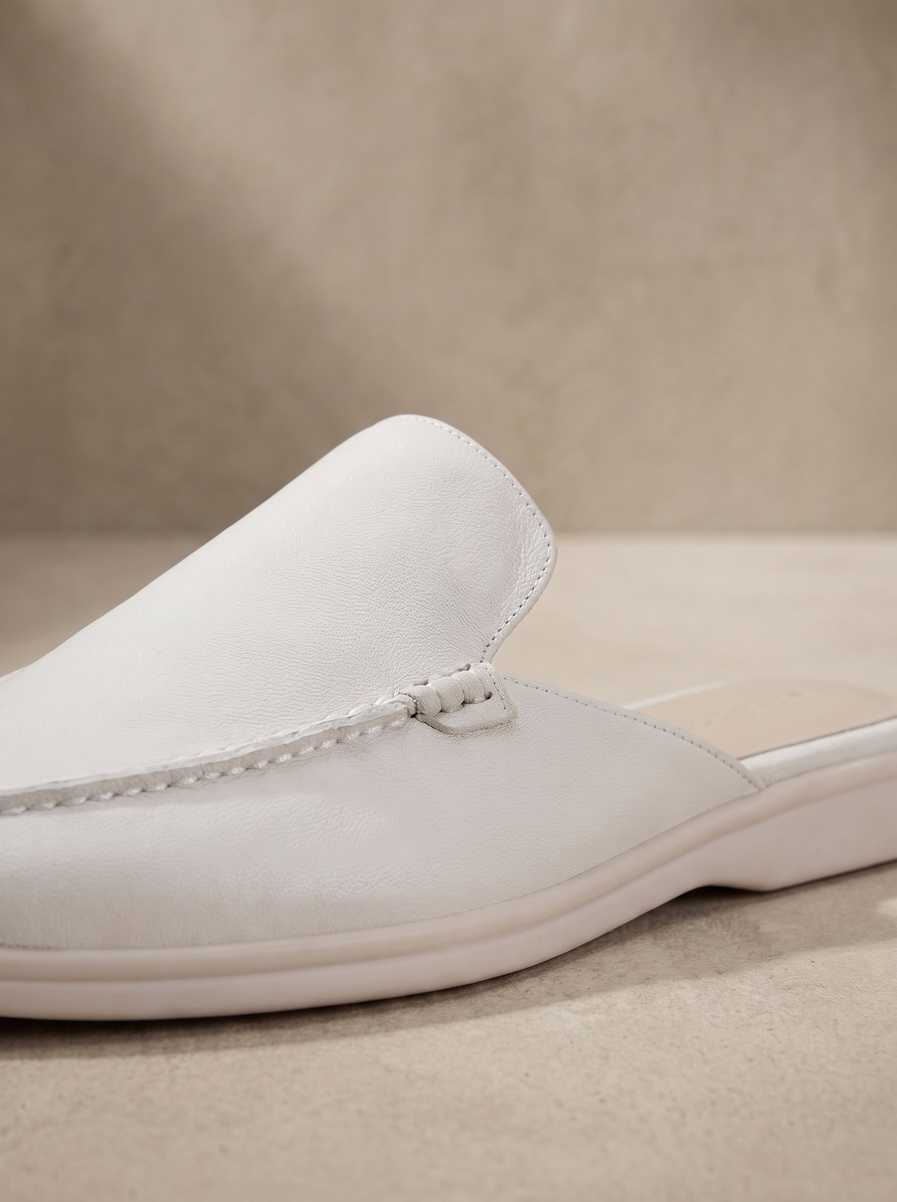 Mocasín mule de ante blanco con detalle de bies y lazo en la pala.