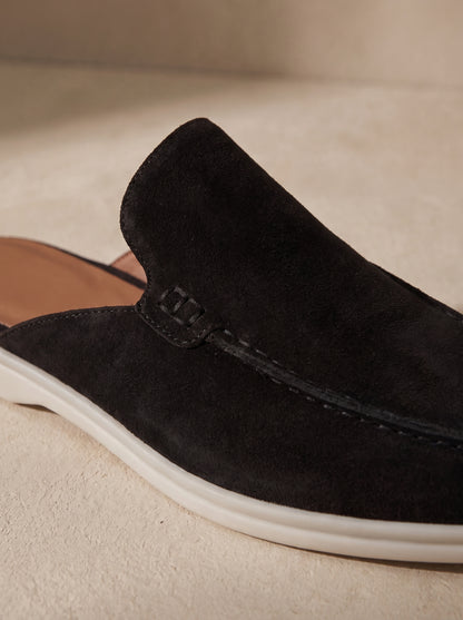 Mocasín mule de ante negro con costuras frontales y suela blanca