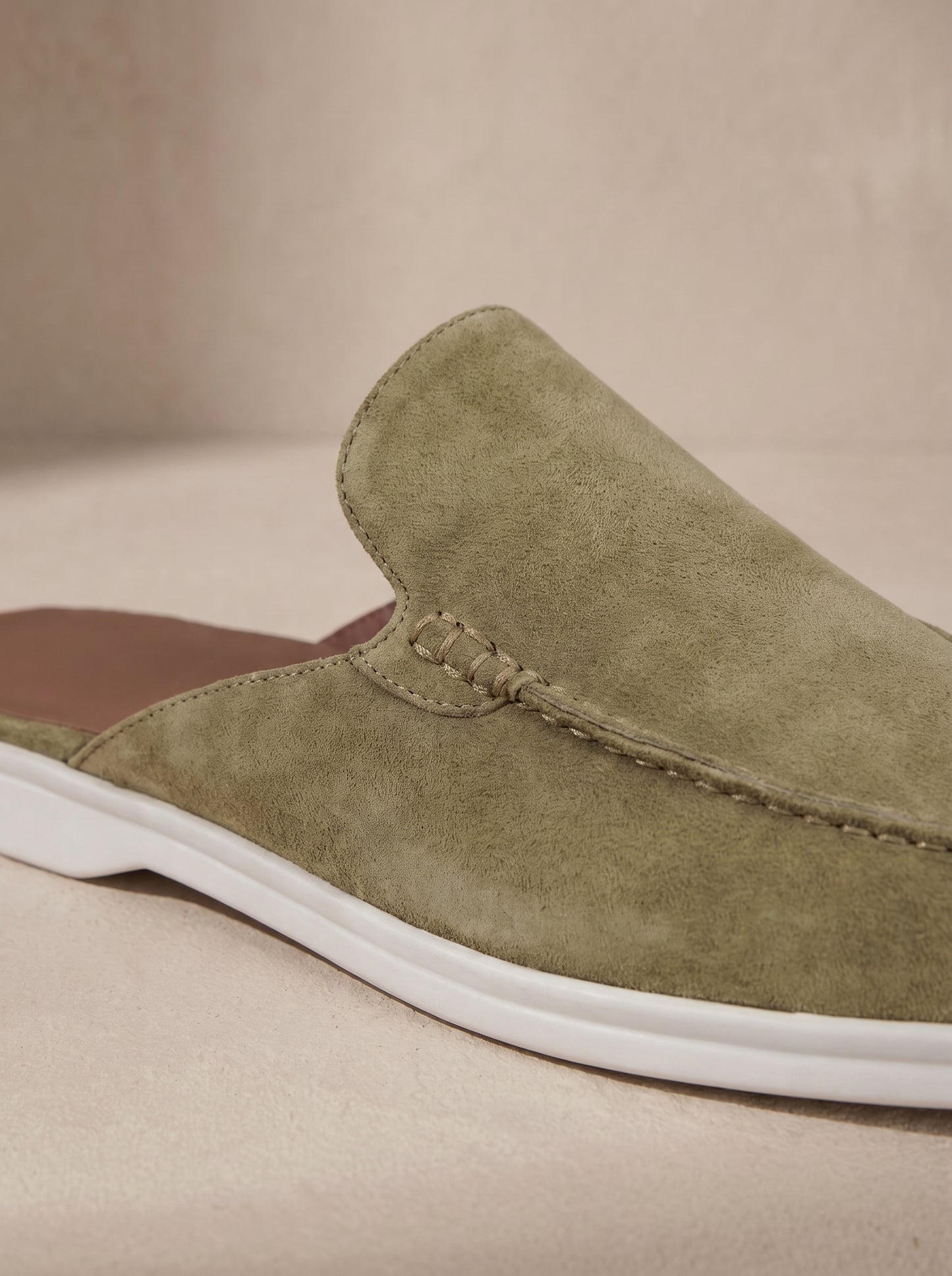 Mocasín mule de ante caqui con suela blanca y costura decorativa