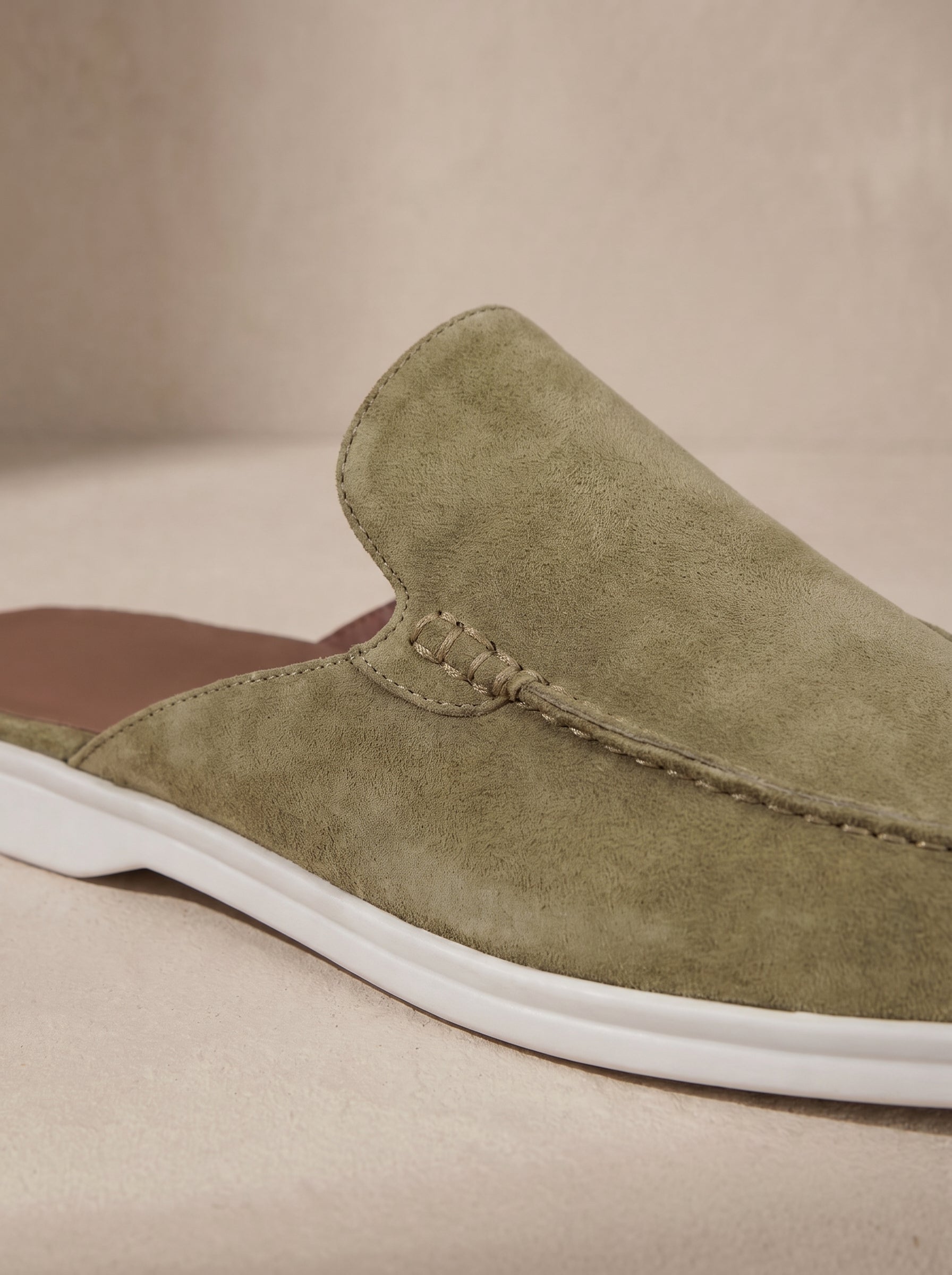 Mocasín mule de ante caqui con suela blanca y costura decorativa