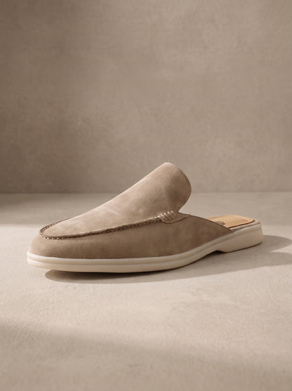 Mocasín mule de ante beige con costuras y suela blanca.