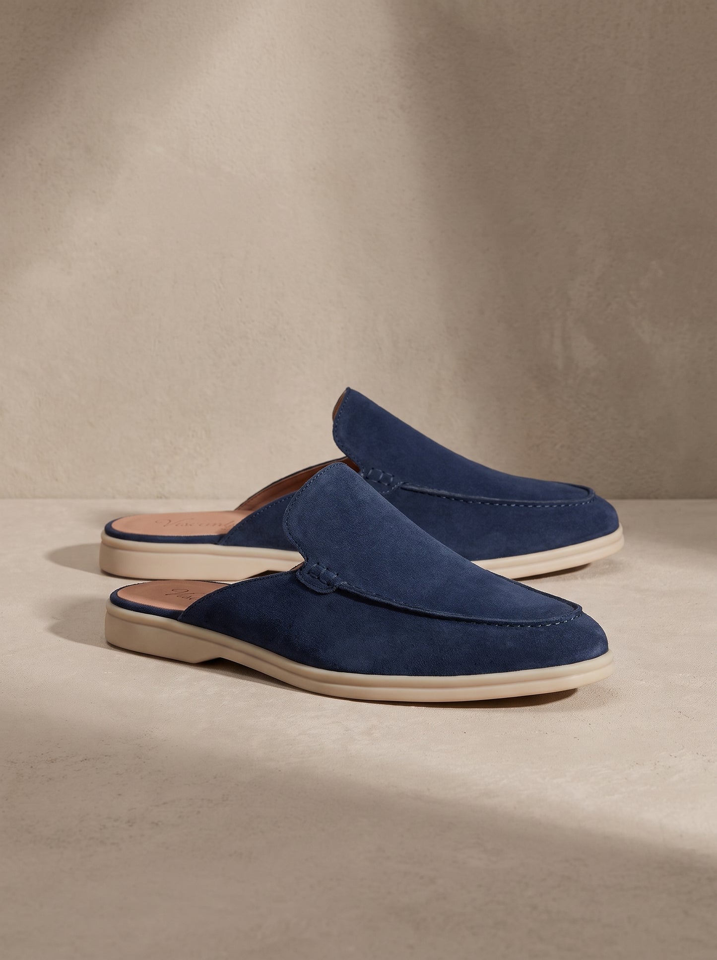 Mocasín mule de ante azul con detalle de costuras y suela clara.