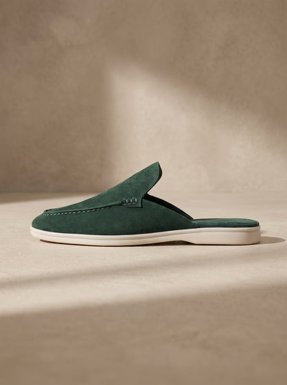 Mocasín mule de ante verde con costura decorativa y suela blanca.