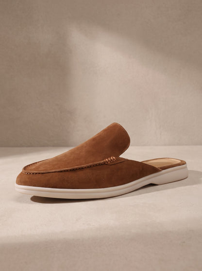 Mocasín mule de ante marrón teja con costuras y suela blanca.