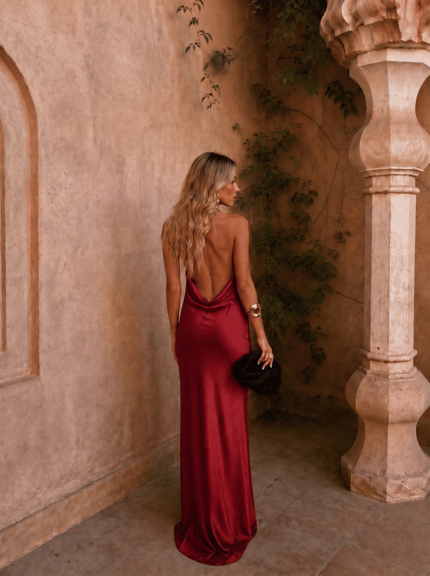 Vestido largo satinado burdeos con espalda descubierta y escote drapeado, estilo sirena.