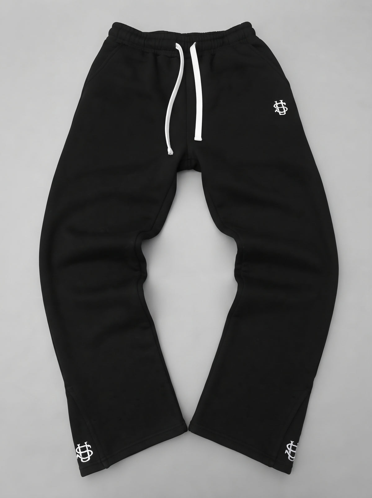 Pantalón chándal negro oversize con cordón blanco y logos bordados en los bajos