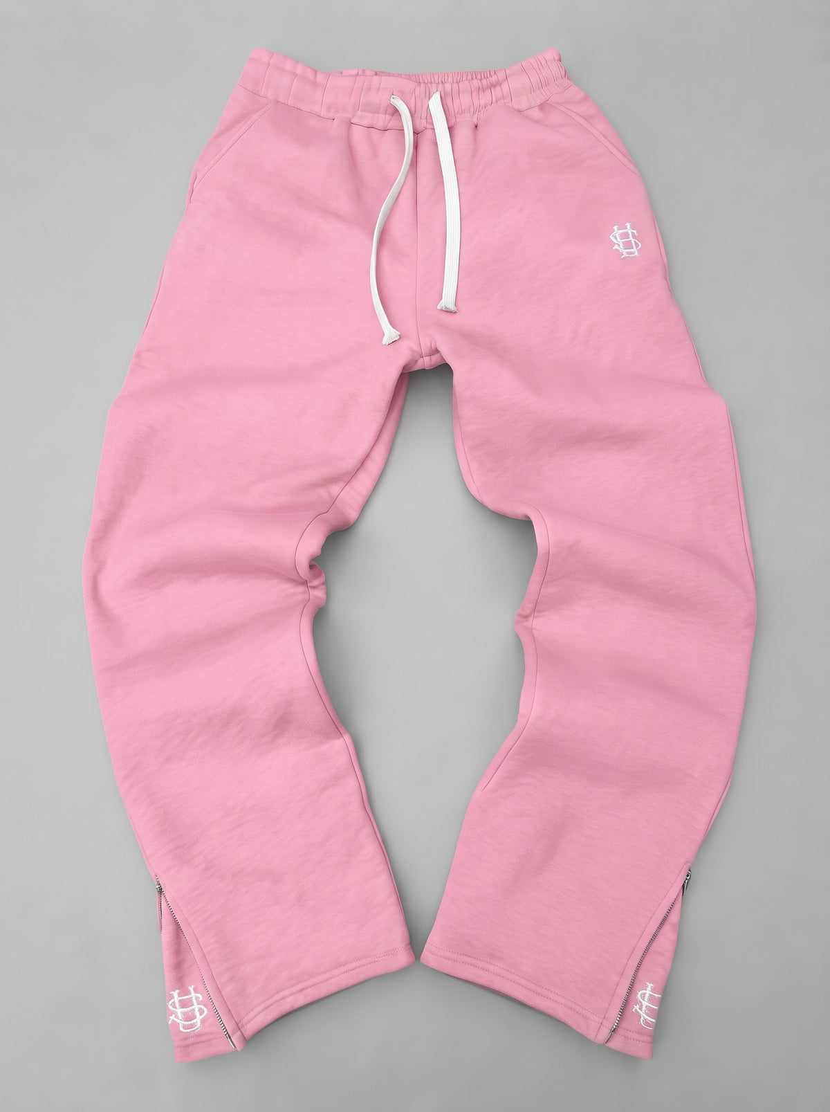 Pantalón chándal rosa oversize con cordón blanco, puños elásticos y logos en los bajos