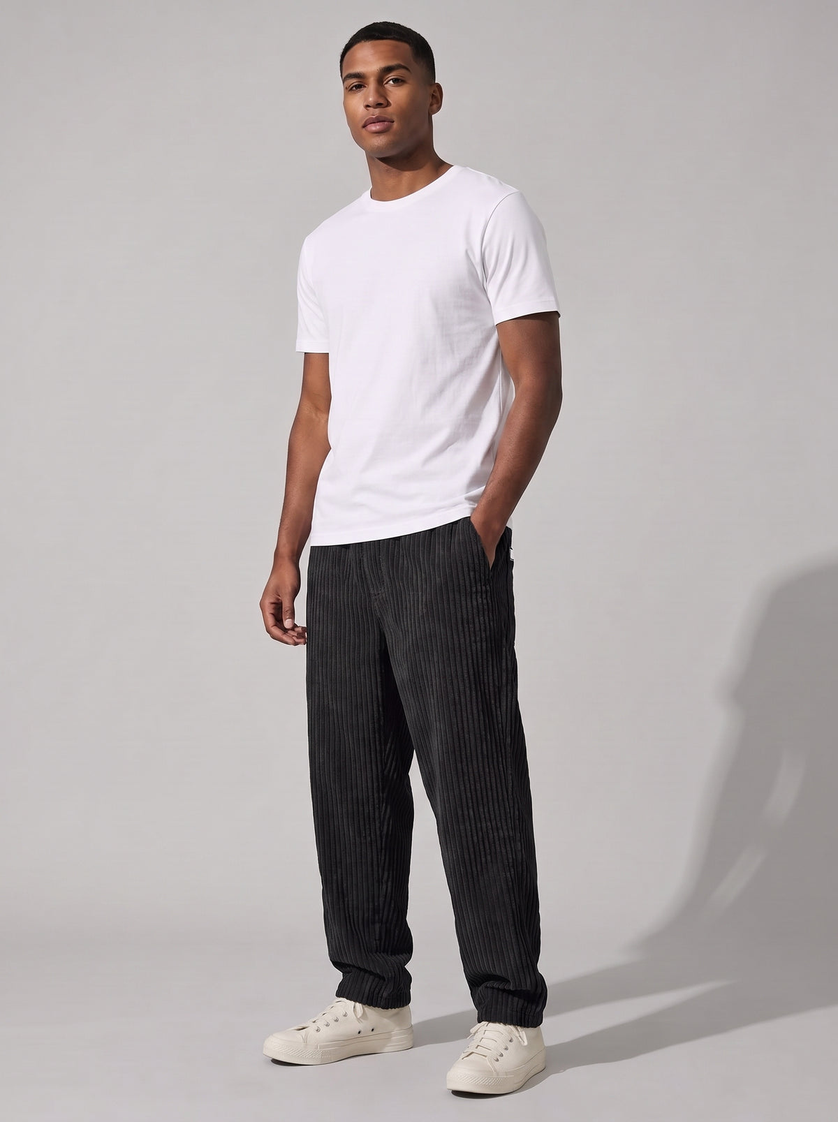 Pantalón de pana relajado negro, pierna recta y puño ajustado, look casual.