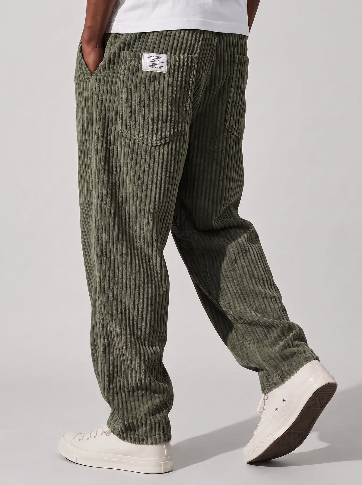 Pantalón de pana relajado verde salvia, vista lateral con bolsillo trasero y textura.
