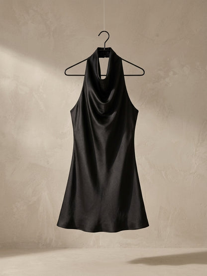 Vestido halter satinado negro, drapeado al cuello, sin mangas, falda recta.