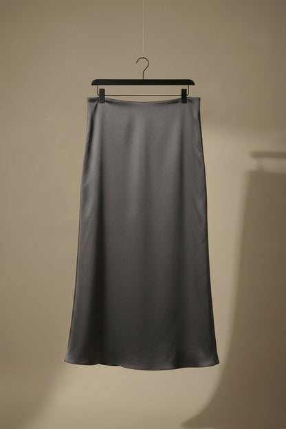 Falda midi satinada gris, colgada con volumen suave y brillo.