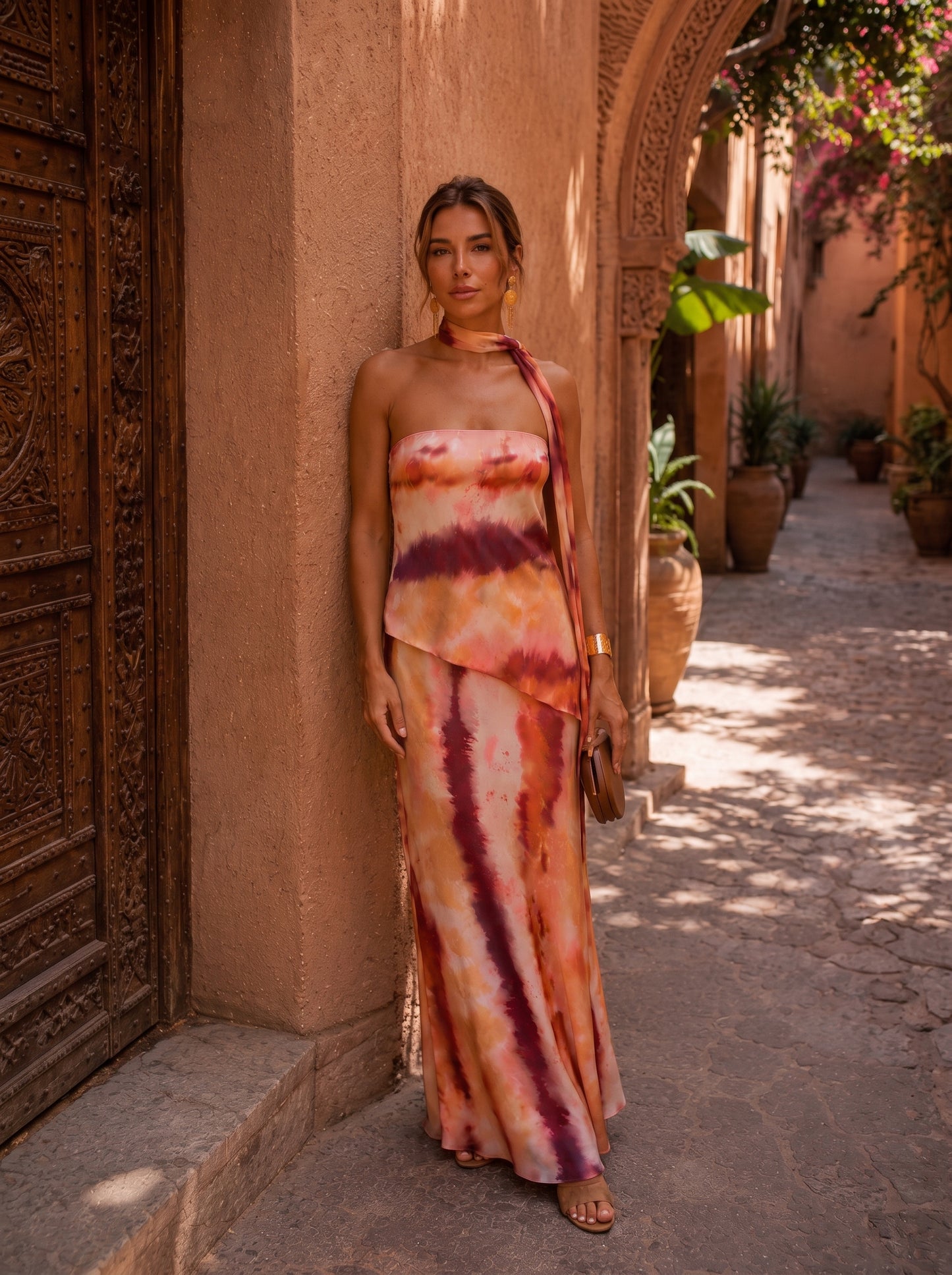 Vestido largo estampado con tiras en el cuello y abertura lateral; tonos terracota, blanco y morado.