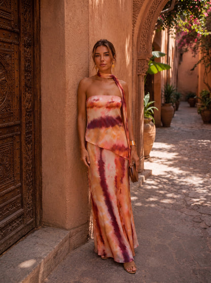 Vestido largo estampado con tiras en el cuello y abertura lateral; tonos terracota, blanco y morado.