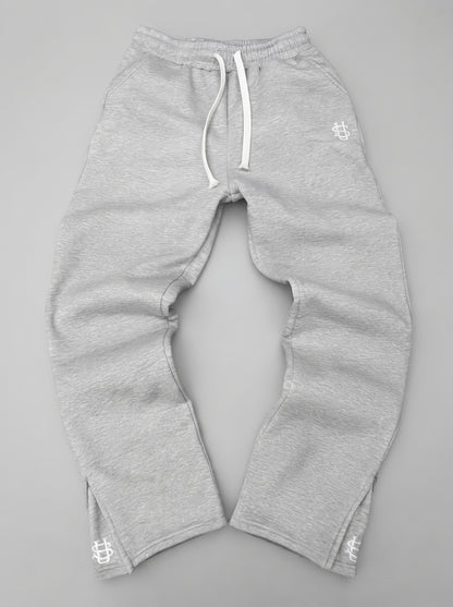 Pantalón chándal gris oversize con cordón blanco, puños elásticos y logos en los bajos