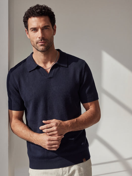 Polo texturizado azul marino de manga corta con cuello y tapeta.