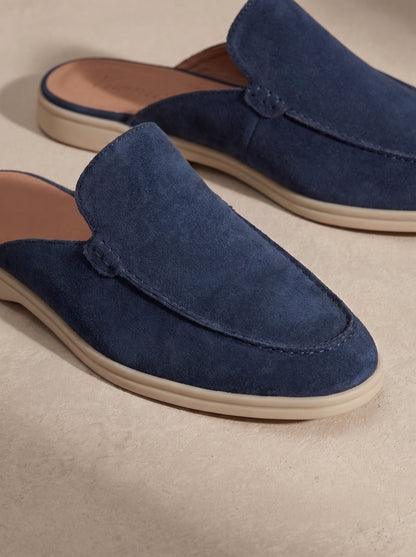 Mocasín mule de ante azul con costuras decorativas y suela beige.