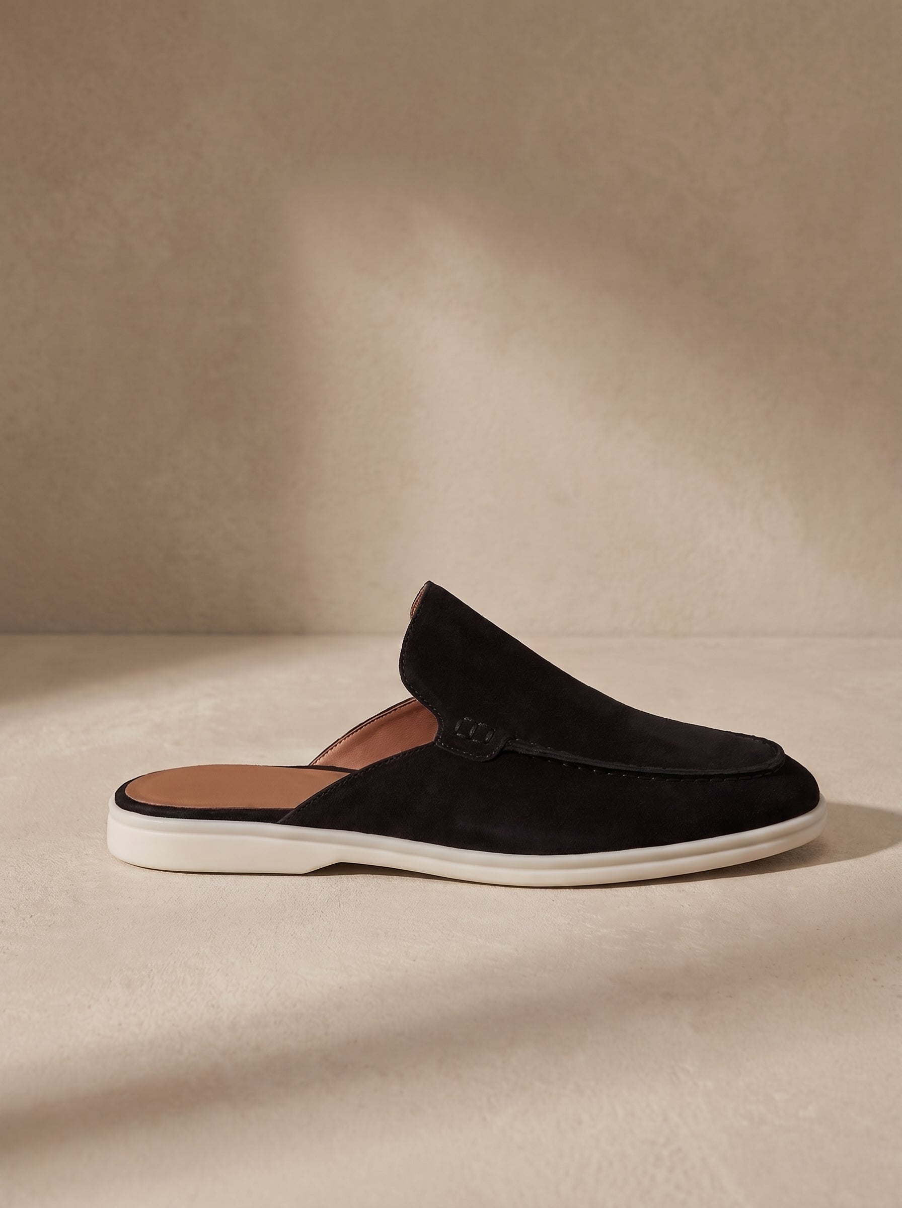 Mocasín mule de ante negro con suela blanca y tira trasera al ras