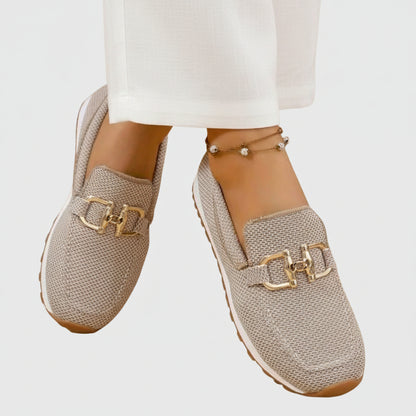 Zapatilla mocasín beige de malla con adorno dorado en la pala y suela antideslizante
