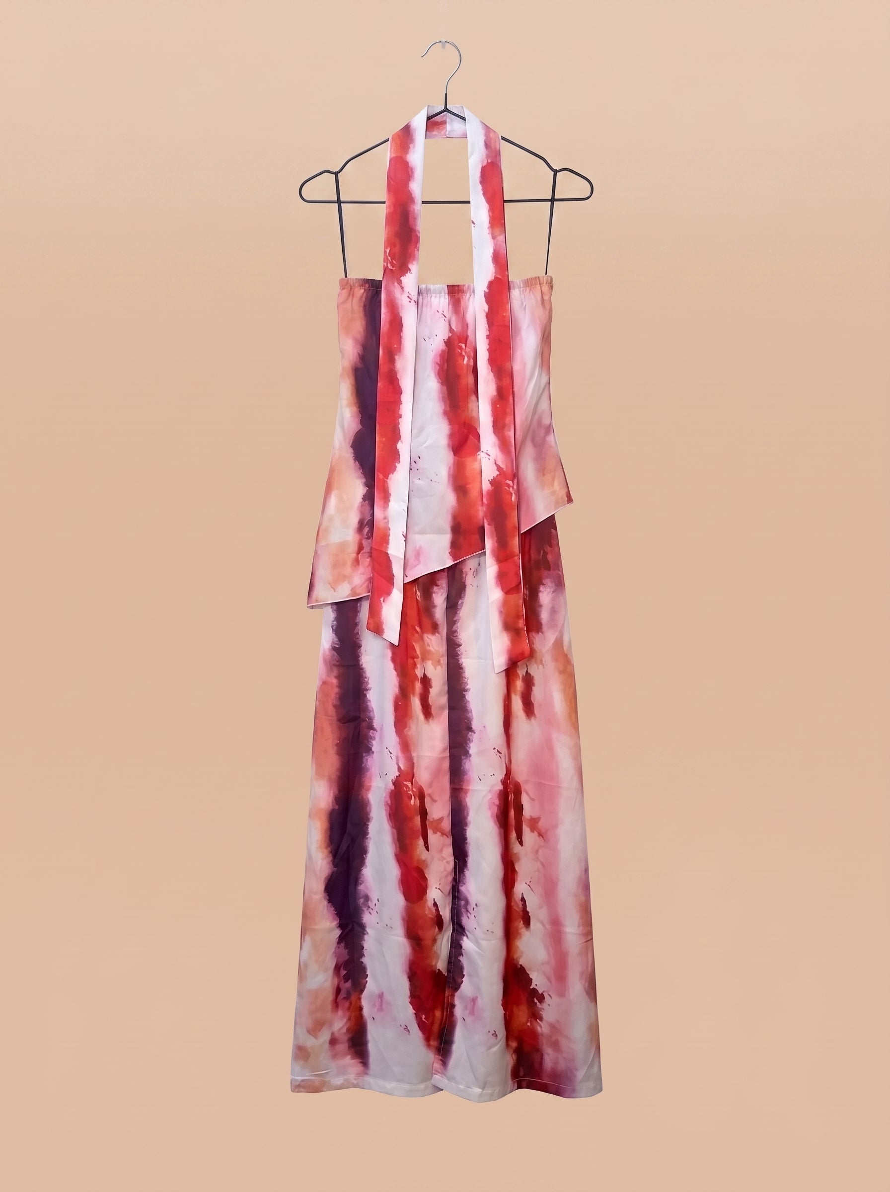 Vestido largo estampado en percha, vista trasera con tiras largas; terracota, blanco y morado.