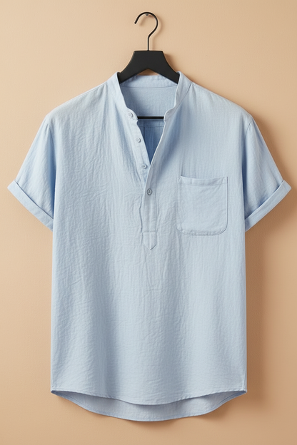 Camisa de lino azul cielo con cuello camisero, tapeta de botones y bolsillo en el pecho