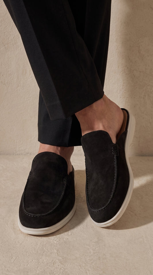 Mocasín mule de ante negro con suela blanca, visto desde el lateral