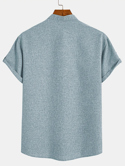 Camiseta con cuello mao azul cielo, botones y estampado cruz en el pecho.