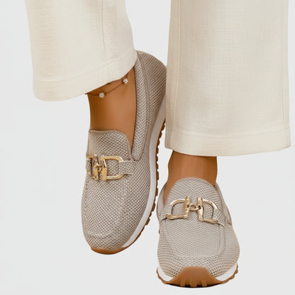 Zapatilla tipo mocasín beige de malla con hebilla dorada y suela marrón