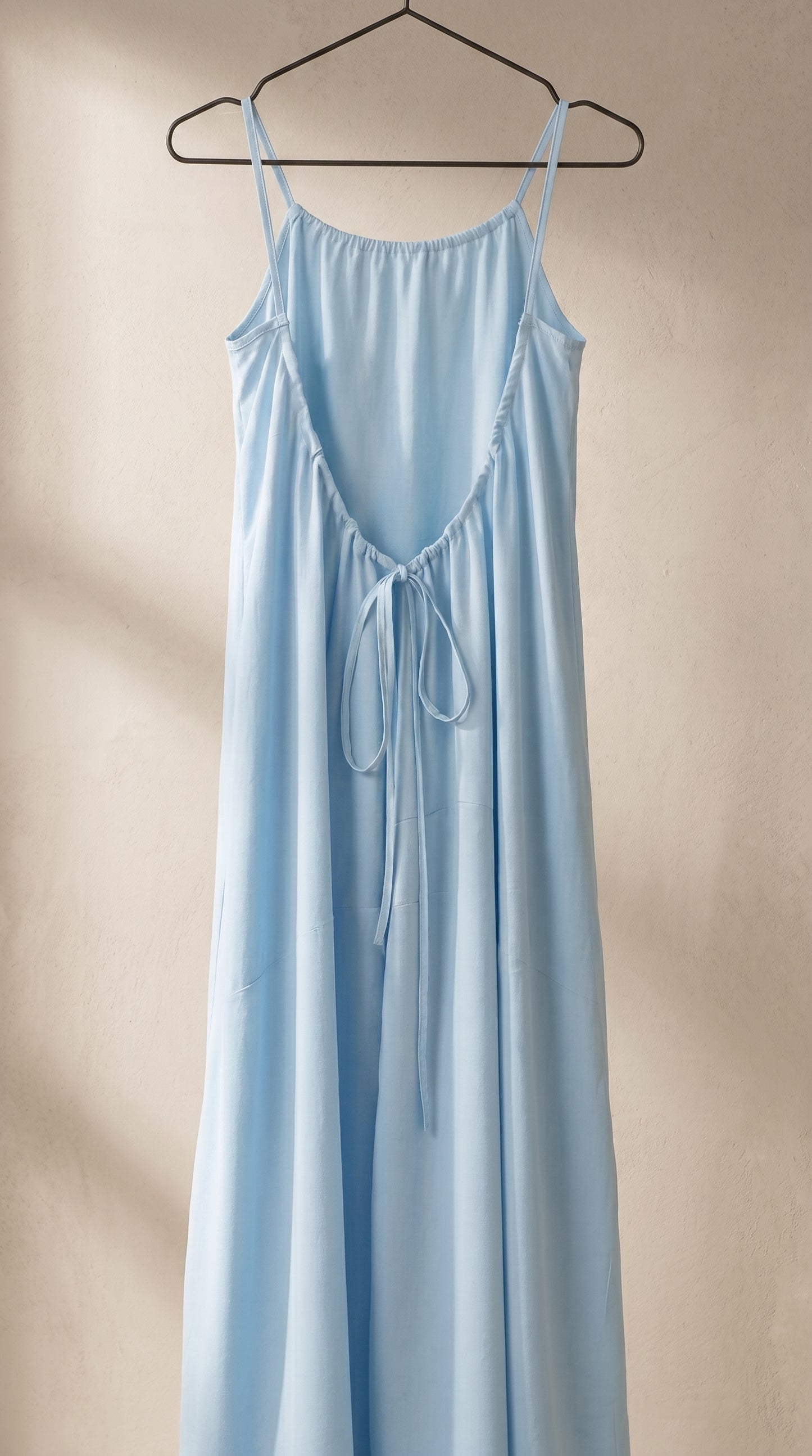 Vestido largo de tirantes azul cielo con abertura cruzada y lazo colgante en el pecho