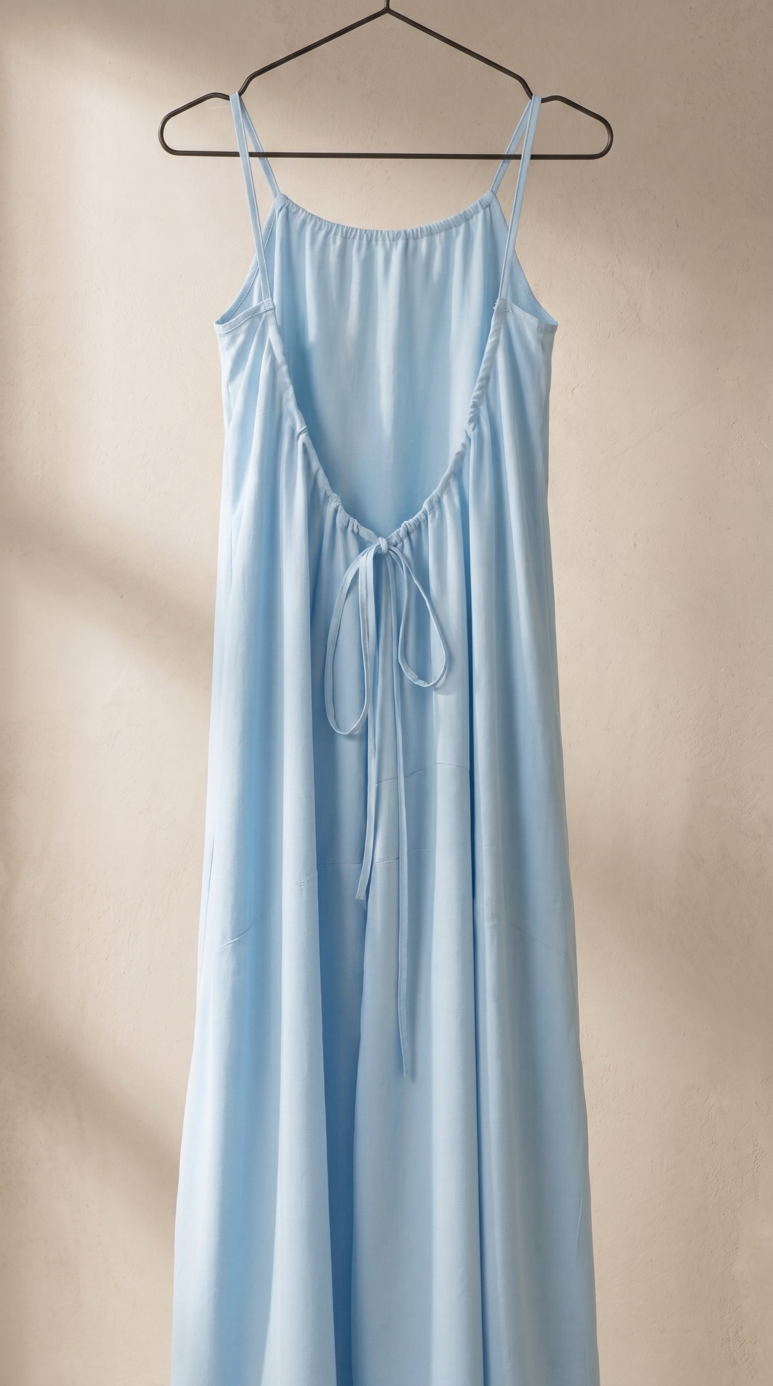Vestido largo de tirantes azul cielo con abertura cruzada y lazo colgante en el pecho