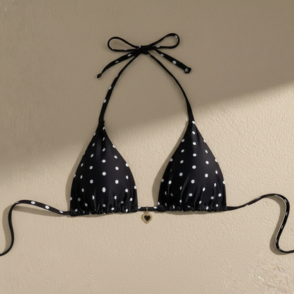 Top bikini negro con lunares blancos y broche central dorado