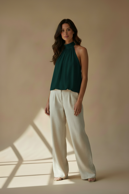 Top halter verde oscuro sin mangas, con cuello alto y pechera drapeada.