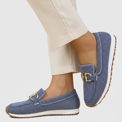 Zapatilla mocasín azul de malla con hebilla dorada y suela marrón